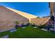 Landscaped backyard featuring artificial turf, colorful potted plants, and a perimeter block wall at 6747 Marjoram St, Las Vegas, NV 89166