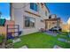 Backyard featuring artificial grass, block wall, covered patio, desert landscaping, and a two-story home at 6747 Marjoram St, Las Vegas, NV 89166
