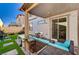 Backyard featuring a covered patio, outdoor seating area, artificial turf, and desert landscaping at 6747 Marjoram St, Las Vegas, NV 89166