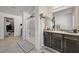 Bright bathroom vanity with granite countertop, dark wood cabinets, framed mirror, with adjacent shower stall at 6747 Marjoram St, Las Vegas, NV 89166