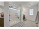 Bright bathroom featuring a glass enclosed shower, light gray tile flooring, and neutral colored walls at 6747 Marjoram St, Las Vegas, NV 89166