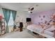 Charming bedroom with purple accent wall, decorated with personal touches and ample natural light at 6747 Marjoram St, Las Vegas, NV 89166