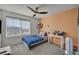 Cozy bedroom with a ceiling fan, blue plaid bedspread and an orange accent wall at 6747 Marjoram St, Las Vegas, NV 89166