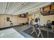 Spacious garage equipped with a home gym area, storage racks, and ample space for parking and storage at 6747 Marjoram St, Las Vegas, NV 89166