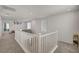 Upstairs hallway featuring carpeted floors, neutral colored walls, and white railing in a well-lit area at 6747 Marjoram St, Las Vegas, NV 89166