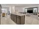 Open kitchen featuring dark cabinets, granite countertops, and a view of the living room at 6747 Marjoram St, Las Vegas, NV 89166