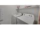 Well-lit laundry room includes a white washer and dryer with convenient shelving at 6747 Marjoram St, Las Vegas, NV 89166