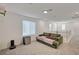 Open living room space with neutral carpet and a comfortable green couch at 6747 Marjoram St, Las Vegas, NV 89166