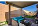 Backyard patio featuring an outdoor seating area under a covered pergola with string lights and artificial turf at 6747 Marjoram St, Las Vegas, NV 89166