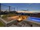 Cozy backyard featuring a sunken fire pit, hot tub, and sport court at 675 Benedict Dr, Las Vegas, NV 89110