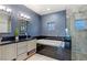 Modern bathroom featuring a soaking tub, double vanity, and glass-enclosed shower at 675 Benedict Dr, Las Vegas, NV 89110