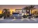 Stunning modern home featuring palm trees, sleek design, and a gated entrance at sunset at 675 Benedict Dr, Las Vegas, NV 89110