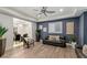 Elegant living room features dark accent wall, shuttered windows, modern fan, and wood-look floors at 675 Benedict Dr, Las Vegas, NV 89110