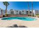 Inviting community pool with palm trees and well-maintained buildings under a clear blue sky at 6800 E Lake Mead Blvd # 1034, Las Vegas, NV 89156