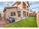 This home boasts a charming backyard with synthetic grass, patio, and multi-story design at 6856 Pipil St, Las Vegas, NV 89166