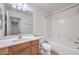 A clean bathroom with a wood vanity, framed mirror and a shower-tub combo at 6856 Pipil St, Las Vegas, NV 89166