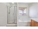 Bright bathroom with glass-enclosed shower and separate soaking tub under a window at 6856 Pipil St, Las Vegas, NV 89166