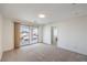 Bright bedroom featuring neutral carpet, sliding glass door to balcony and bathroom access at 6856 Pipil St, Las Vegas, NV 89166