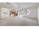 Bright living room featuring neutral carpet, ceiling fan, and sliding glass doors to the backyard at 6856 Pipil St, Las Vegas, NV 89166