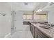 Bright bathroom with double vanity, granite counters, and tile flooring at 7973 Macklin St, Las Vegas, NV 89129