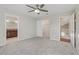 Bedroom with ceiling fan, carpet, and two entryways in neutral tones at 7973 Macklin St, Las Vegas, NV 89129