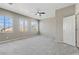 Bedroom featuring neutral carpet, ceiling fan, and large windows at 7973 Macklin St, Las Vegas, NV 89129