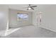Bright carpeted bedroom with ceiling fan and natural light from the window at 7973 Macklin St, Las Vegas, NV 89129
