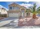 Inviting two-story home boasts desert landscaping, a two-car garage, and a bright stucco exterior at 7973 Macklin St, Las Vegas, NV 89129