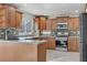 Charming kitchen with granite counters, tile backsplash, stainless steel appliances, and wood cabinets at 7973 Macklin St, Las Vegas, NV 89129