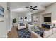 A well-staged living room featuring a modern ceiling fan and plenty of natural light at 7973 Macklin St, Las Vegas, NV 89129