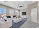 Bright living room with modern furniture, many windows, and ceiling fan at 7973 Macklin St, Las Vegas, NV 89129