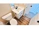 Bathroom with a toilet, modern vanity with storage, white countertop and wood-look flooring at 8216 Chimney Bluffs St, North Las Vegas, NV 89085