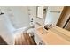 Bright bathroom featuring a tub with white tile surround, modern fixtures, and wood-look floors at 8216 Chimney Bluffs St, North Las Vegas, NV 89085