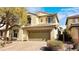Charming two-story home featuring a brick driveway, neutral exterior, and lush landscaping at 8216 Chimney Bluffs St, North Las Vegas, NV 89085
