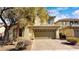 Inviting two-story home with a brick driveway, tan exterior, and a well-manicured lawn at 8216 Chimney Bluffs St, North Las Vegas, NV 89085