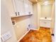 Laundry room with white cabinets, tile floors, and a sink at 8216 Chimney Bluffs St, North Las Vegas, NV 89085