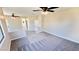 Spacious living room with neutral walls, plush carpet, and ceiling fans, bathed in natural light at 8216 Chimney Bluffs St, North Las Vegas, NV 89085