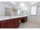 Bathroom featuring double sinks, vanity with dark wood, and large mirror at 9748 Villa Lorena Ave, Las Vegas, NV 89147