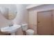 Cozy half-bathroom featuring a modern sink, toilet, and a neutral-toned door at 9748 Villa Lorena Ave, Las Vegas, NV 89147