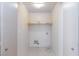 Compact laundry room with tile floor, storage shelf, and washer/dryer hookups at 9748 Villa Lorena Ave, Las Vegas, NV 89147