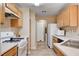 Functional kitchen featuring wooden cabinets, white appliances, and tile flooring at 10066 Delicate Dew St, Las Vegas, NV 89183