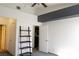 Bright bedroom featuring a ceiling fan and decorative wooden ladder-style shelf at 10553 Pine Pointe Ave # 201, Las Vegas, NV 89144