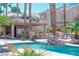 Inviting pool area with clear blue water, comfortable lounge chairs, and lush palm trees for relaxation at 10553 Pine Pointe Ave # 201, Las Vegas, NV 89144