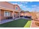Backyard with a covered patio, seating area and artificial turf; perfect for relaxation and entertainment at 10568 Pelican Island Ave, Las Vegas, NV 89166