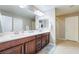 Bathroom featuring double sinks with modern vanities, bright lighting, and a separate shower stall at 10568 Pelican Island Ave, Las Vegas, NV 89166