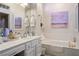 Bright bathroom featuring a soaking tub and a vanity with white cabinets at 10716 Bennington Ct, Las Vegas, NV 89134