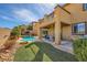 Desert backyard featuring artificial grass, covered patio, dining set, BBQ and shimmering pool at 1178 Yellow Orchid St, Henderson, NV 89002