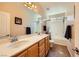 This is a bathroom with double sinks, tile floors, and a shower-tub combo with black fixtures at 1178 Yellow Orchid St, Henderson, NV 89002