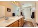 Bright bathroom featuring double sinks, a large mirror, and bathtub with shower at 1178 Yellow Orchid St, Henderson, NV 89002