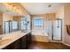 Luxury bathroom with dual sinks, soaking tub, walk-in shower, and picturesque window views at 1178 Yellow Orchid St, Henderson, NV 89002